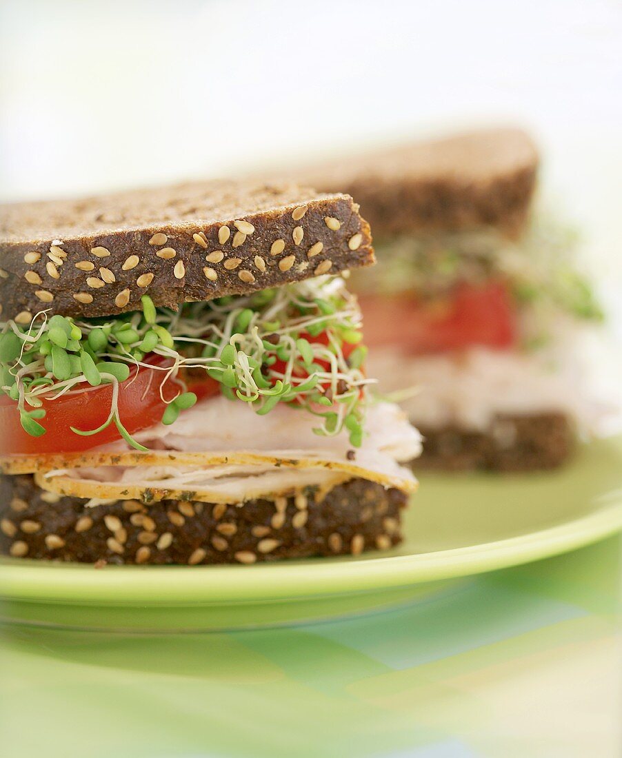 Turkey, tomato and sprout sandwich, halved