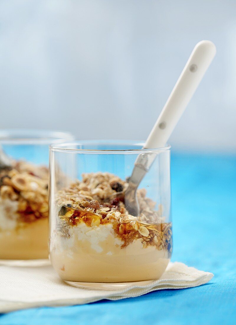 Two glasses of muesli with honey and yoghurt