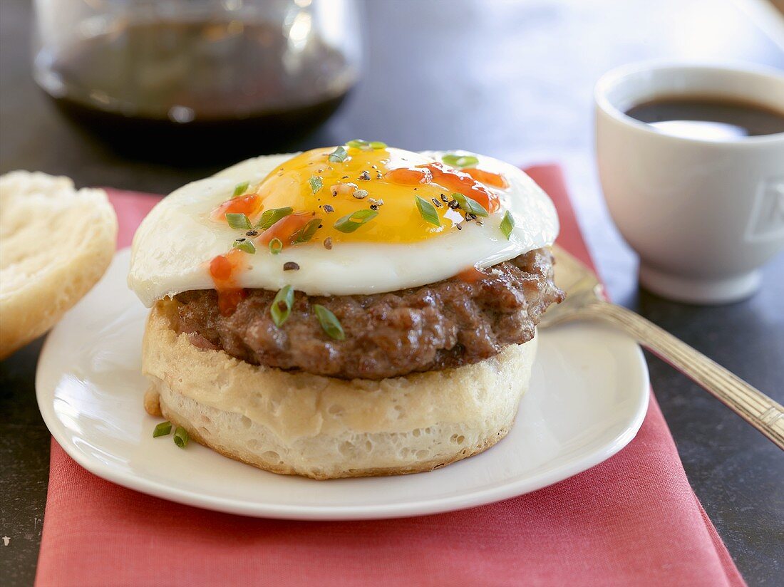English muffin with burger and fried egg, coffee (USA)