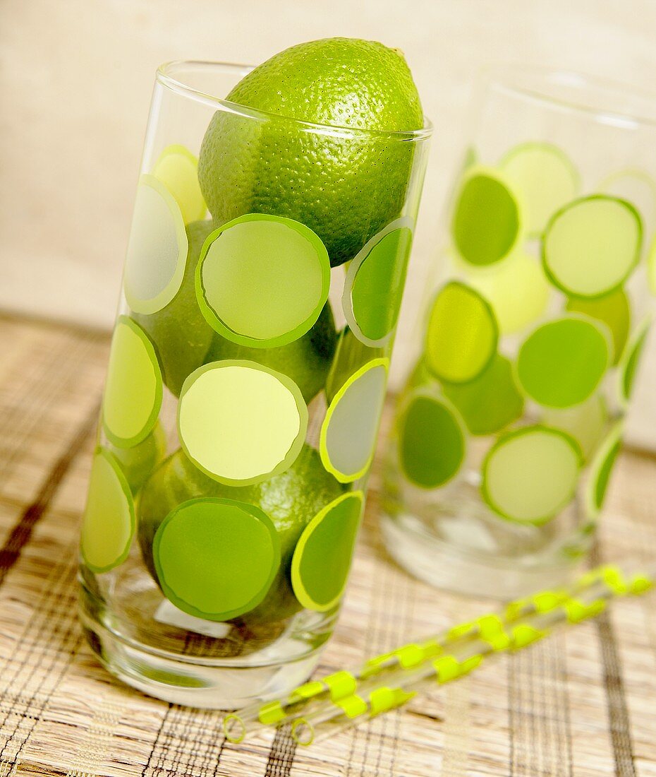 Drei Limetten im Glas mit grünen Punkten