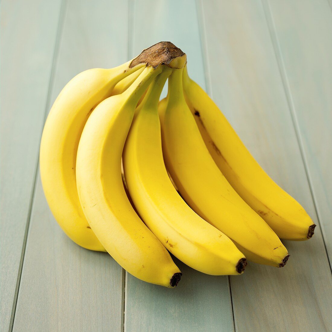 A bunch of bananas on blue painted wood