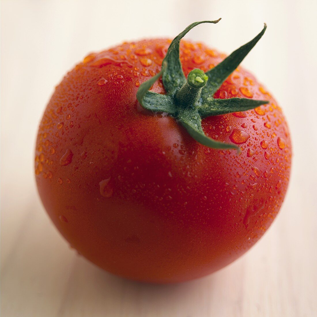 A tomato with drops of water