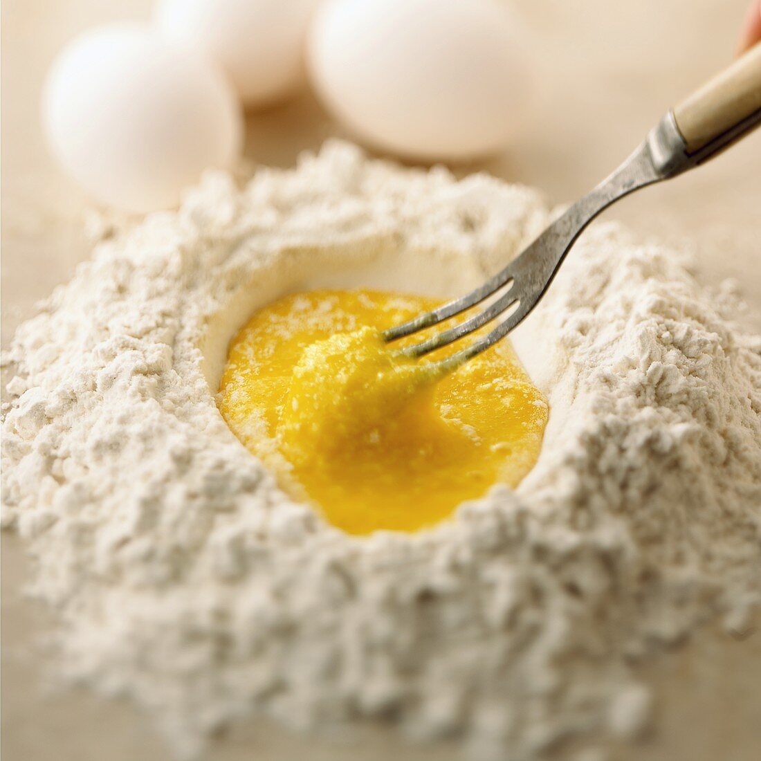 Making pasta dough: mixing egg with flour