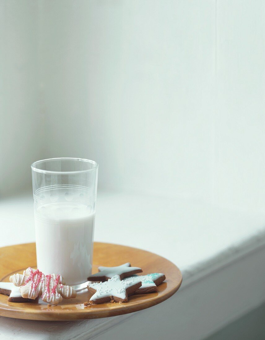 A glass of milk with assorted Christmas biscuits