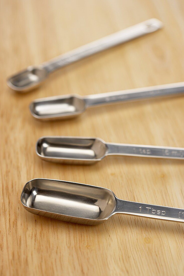 Set of Metal Measuring Spoons on Wood