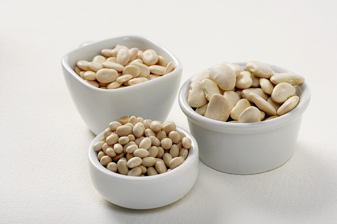 Three Small White Bowls with Assorted Dried Beans, White Background