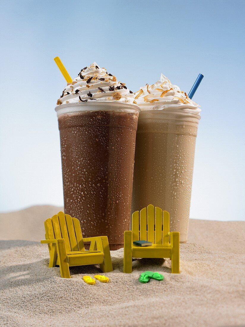 Schokoladenshake und Kaffeeshake im Sand, zwei kleine Stühle