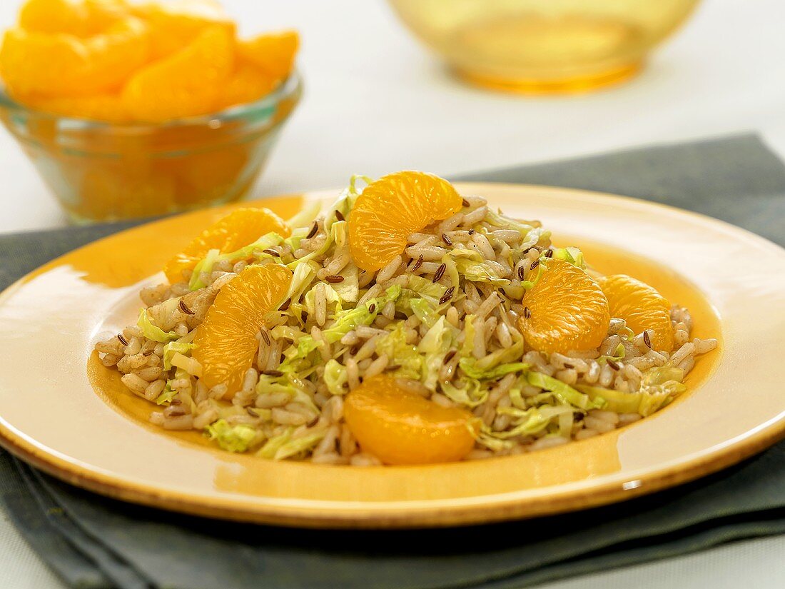 Caraway Cabbage and Rice with Orange Wedges on a Plate