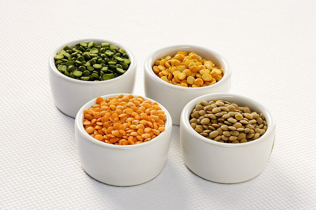 Four Small Bowls Full of Split Peas and Lentils, White Background