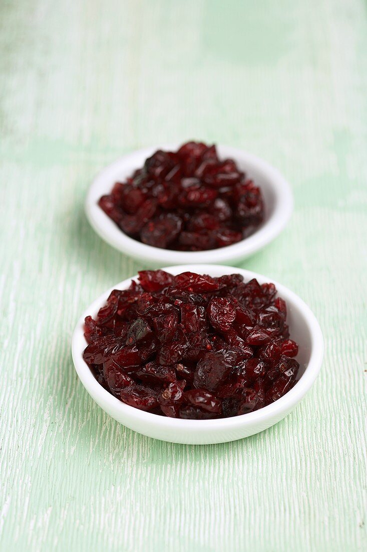 Two Small White Bowls of Dried Cranberries