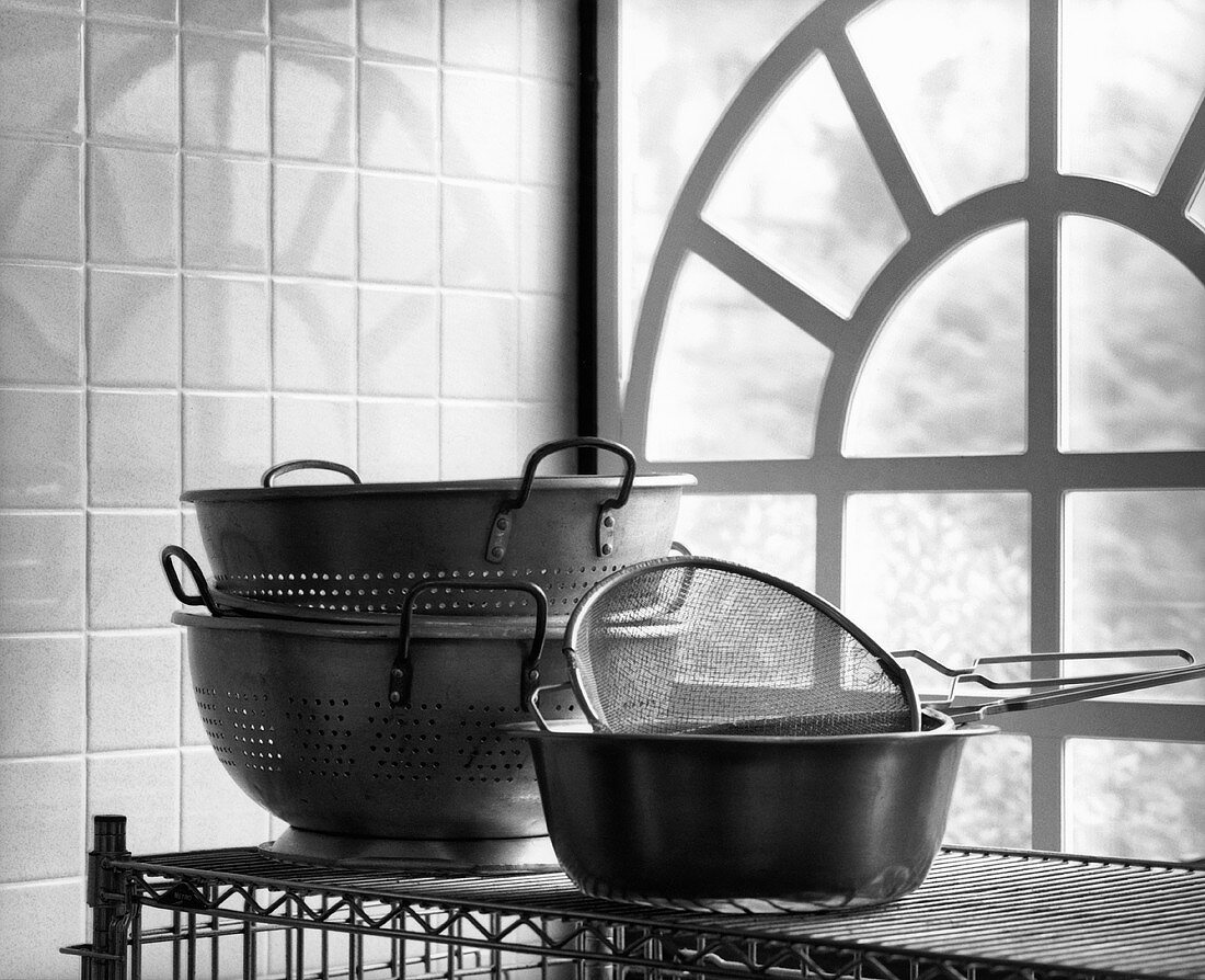 Assorted Colanders on a Rack by a Large Window