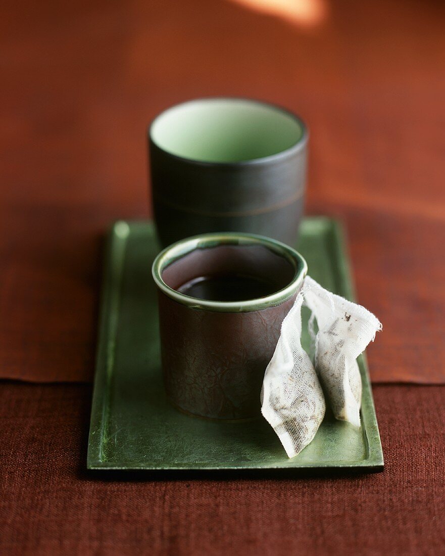 Zwei Teeschalen aus Japan mit Teebeuteln auf Tablett