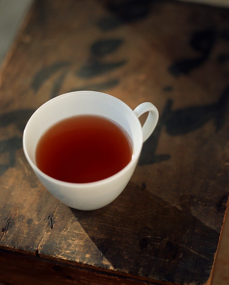 Teetasse auf alter Holzkiste mit asiatischen Schriftzeichen