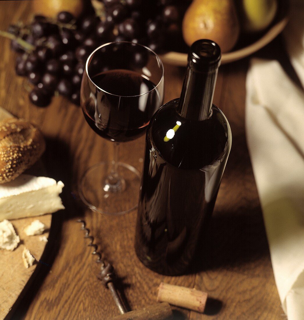 Rotwein in Flasche und Glas; Obst; Käse; Korkenzieher