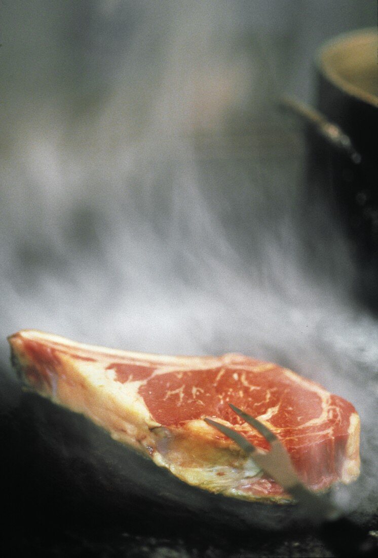 Ein rohes Rib Steak auf dem Grill