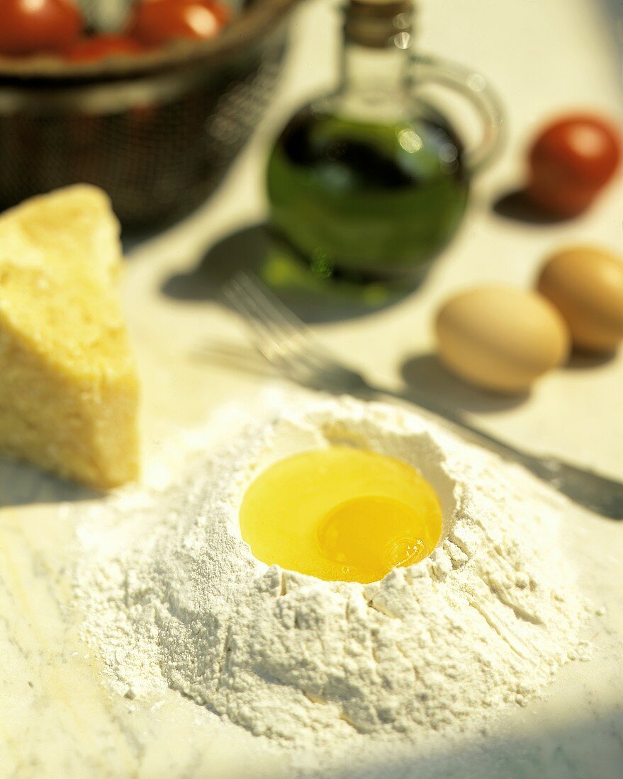 Mehl mit aufgeschlagenem Ei, Parmesan, Olivenöl, Tomaten
