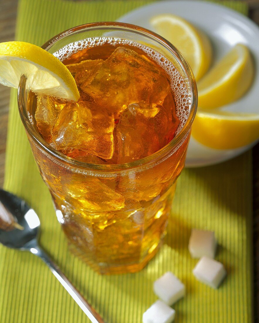 Iced tea in glass; lemon wedges; sugar cubes