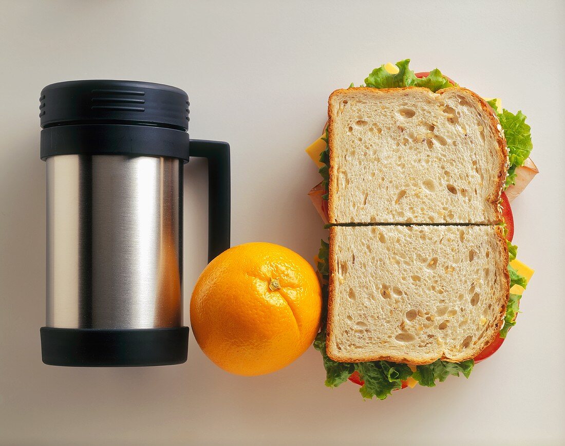 Thermosbecher, eine Orange & Sandwich mit Putenbrust