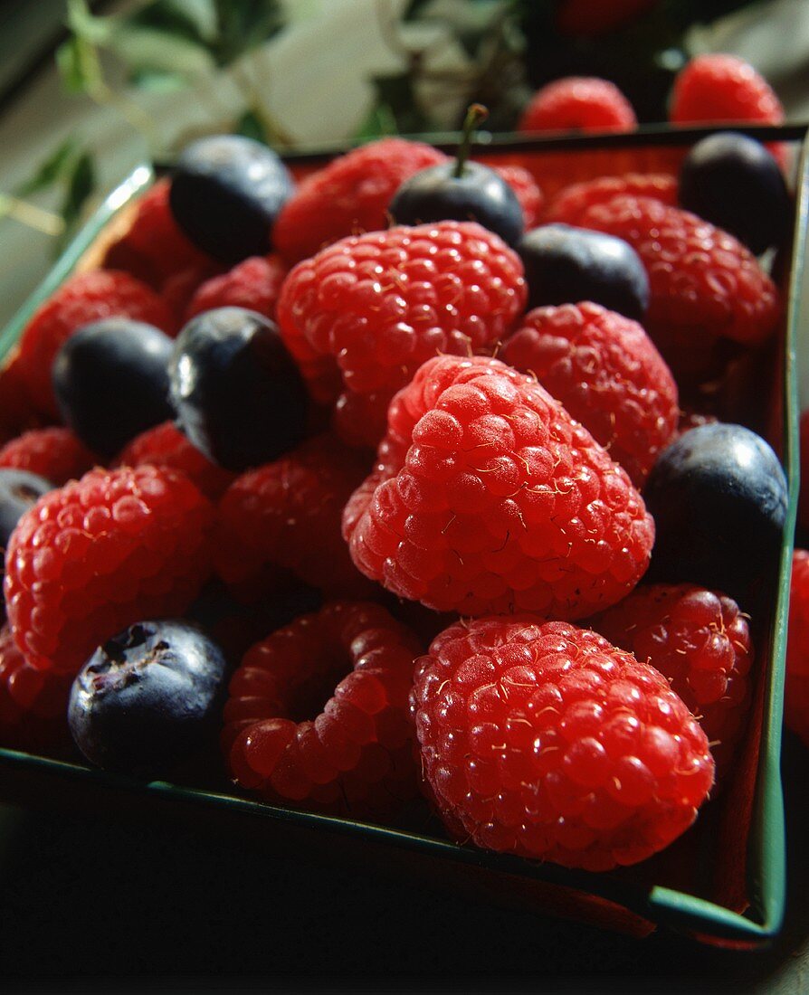 Himbeeren und Blaubeeren in einem Körbchen