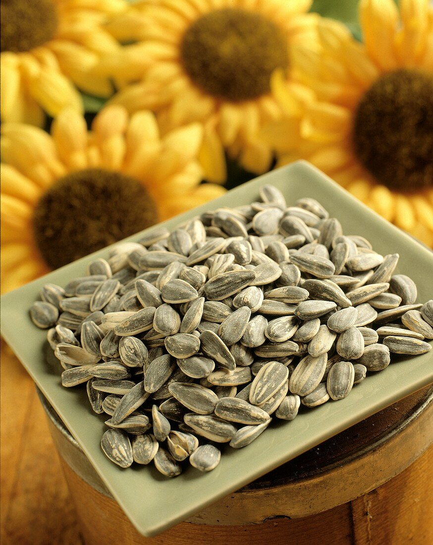 Sunflower Seeds in a Dish with Sunflowers in the Background