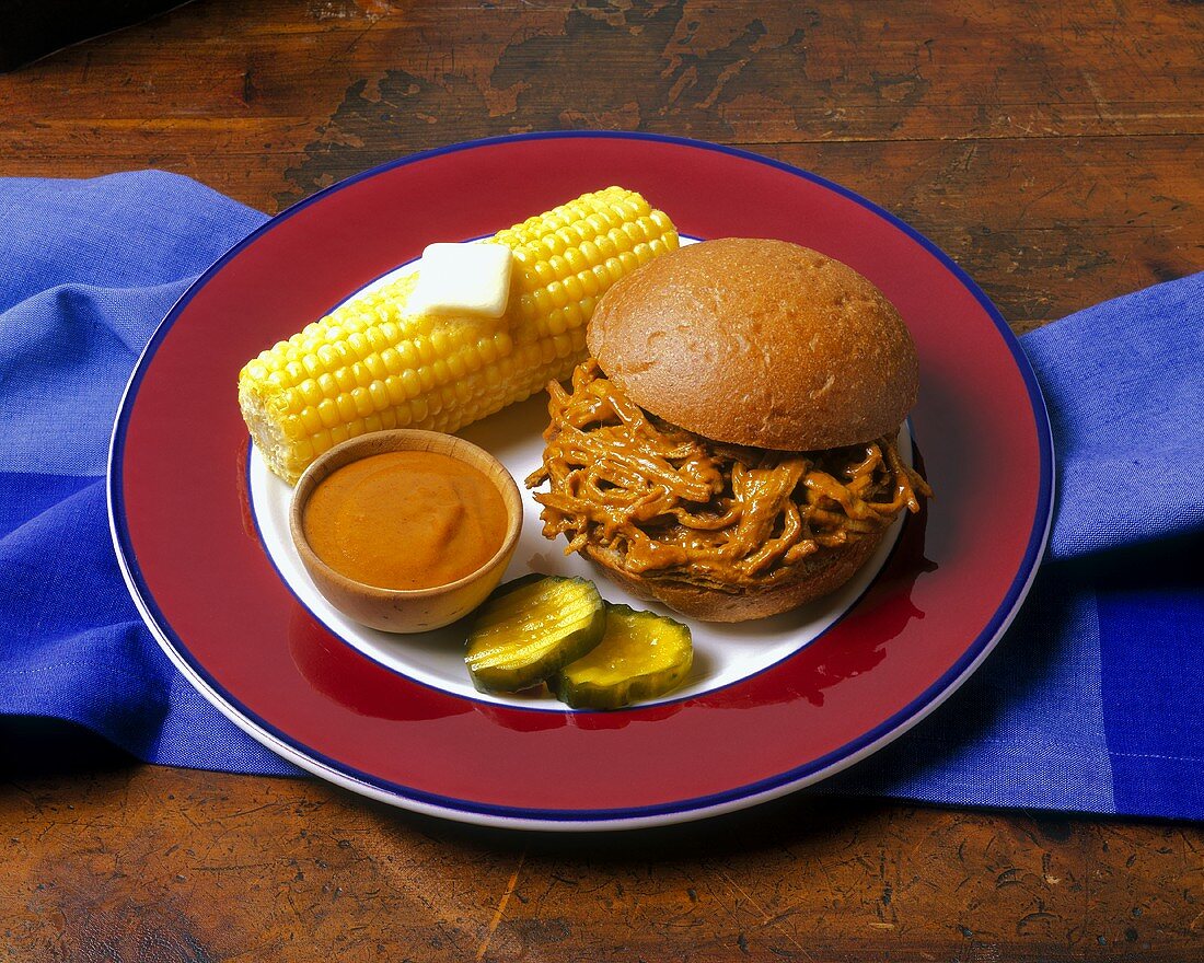 Sandwich mit Schweinegeschnetzeltem, Maiskolben, Essiggurken