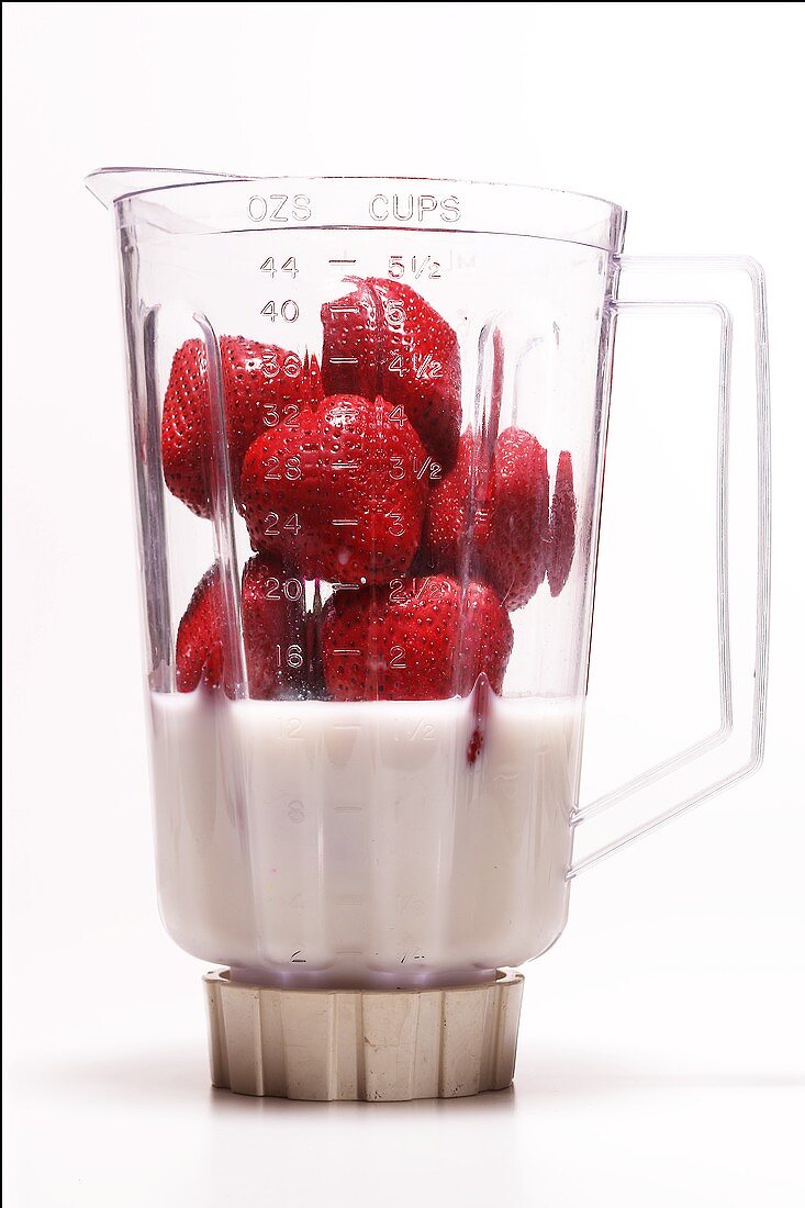 Erdbeeren mit Milch (oder Sahne) Messbecher eines Mixers