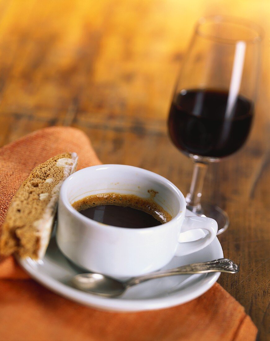 Eine Tasse Espresso mit Biscotti und ein Glas Rotwein