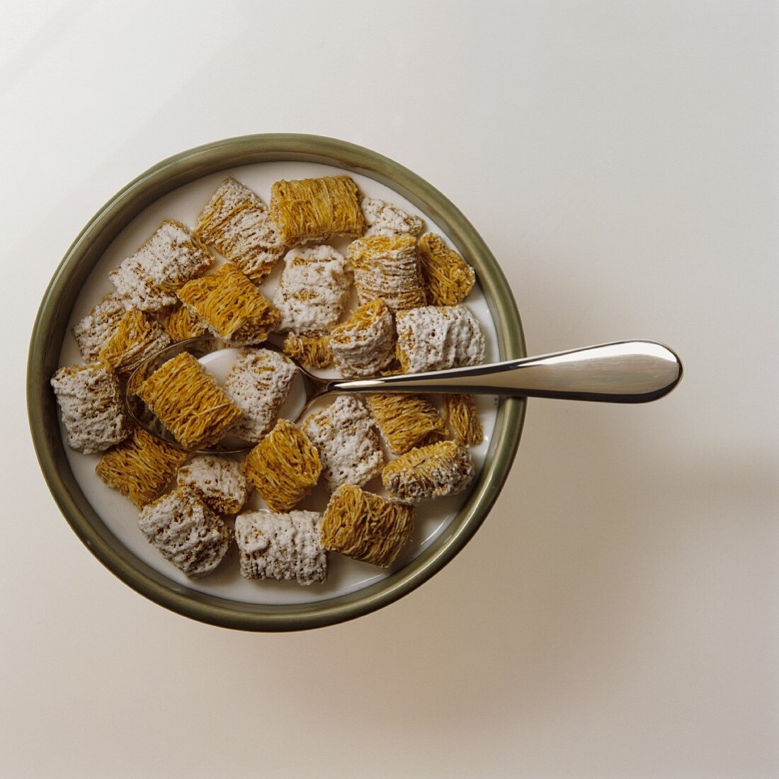 Bowl of Frosted Shredded Wheat Cereal with Milk and a Spoon; From Above