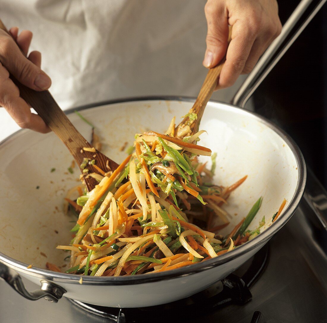 Gemüsejulienne im Wok vermischen