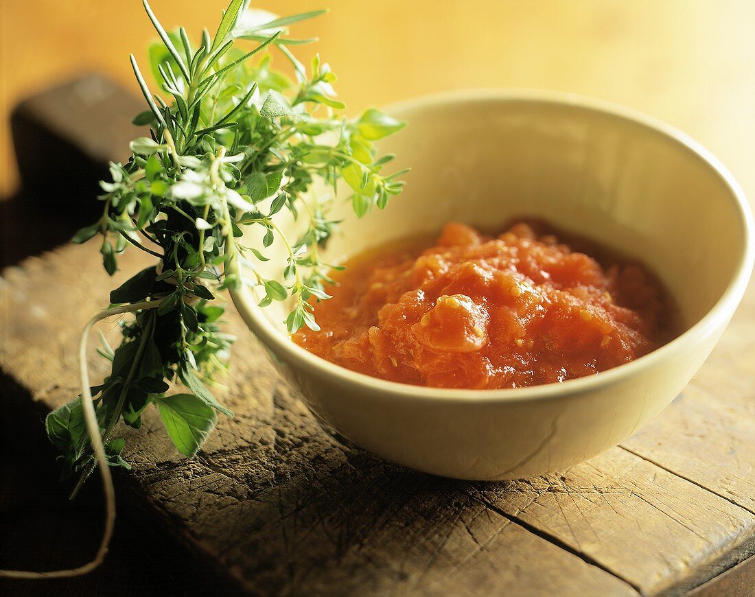 Tomatencoulis im Schälchen; frischer Kräuterstrauss