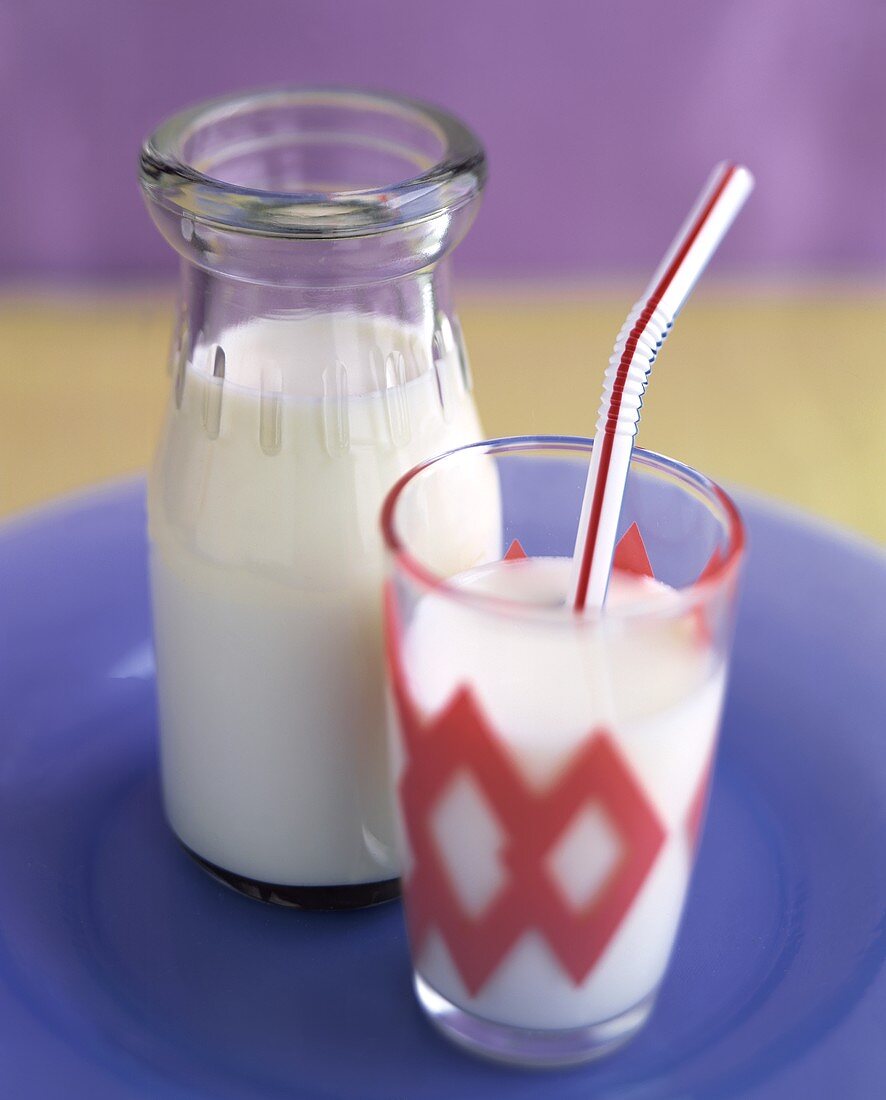 Milch in der Flasche und im Glas mit Strohhalm