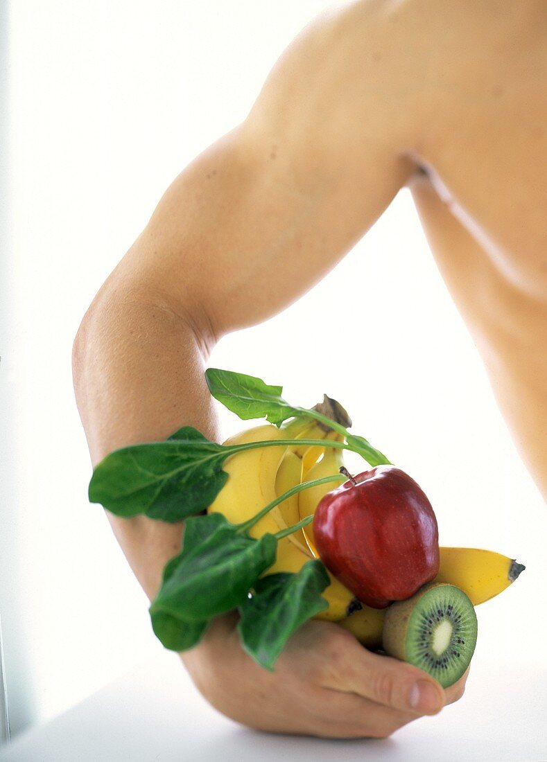 Kraft durch Vitamine: Mann hält verschiedene Früchte
