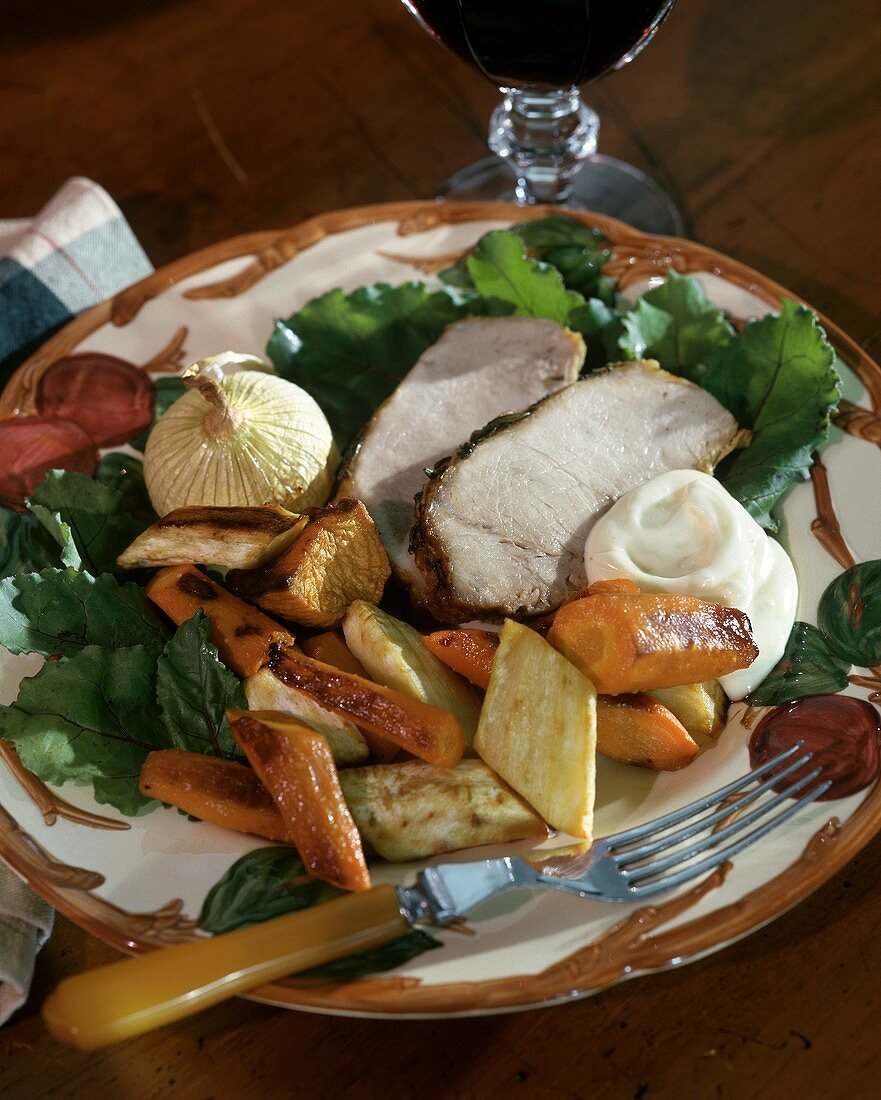 Sliced roast pork with vegetables and sour cream