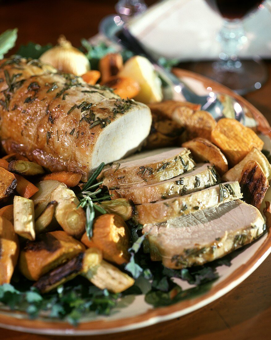 Roast pork, slices carved, with rosemary and vegetables