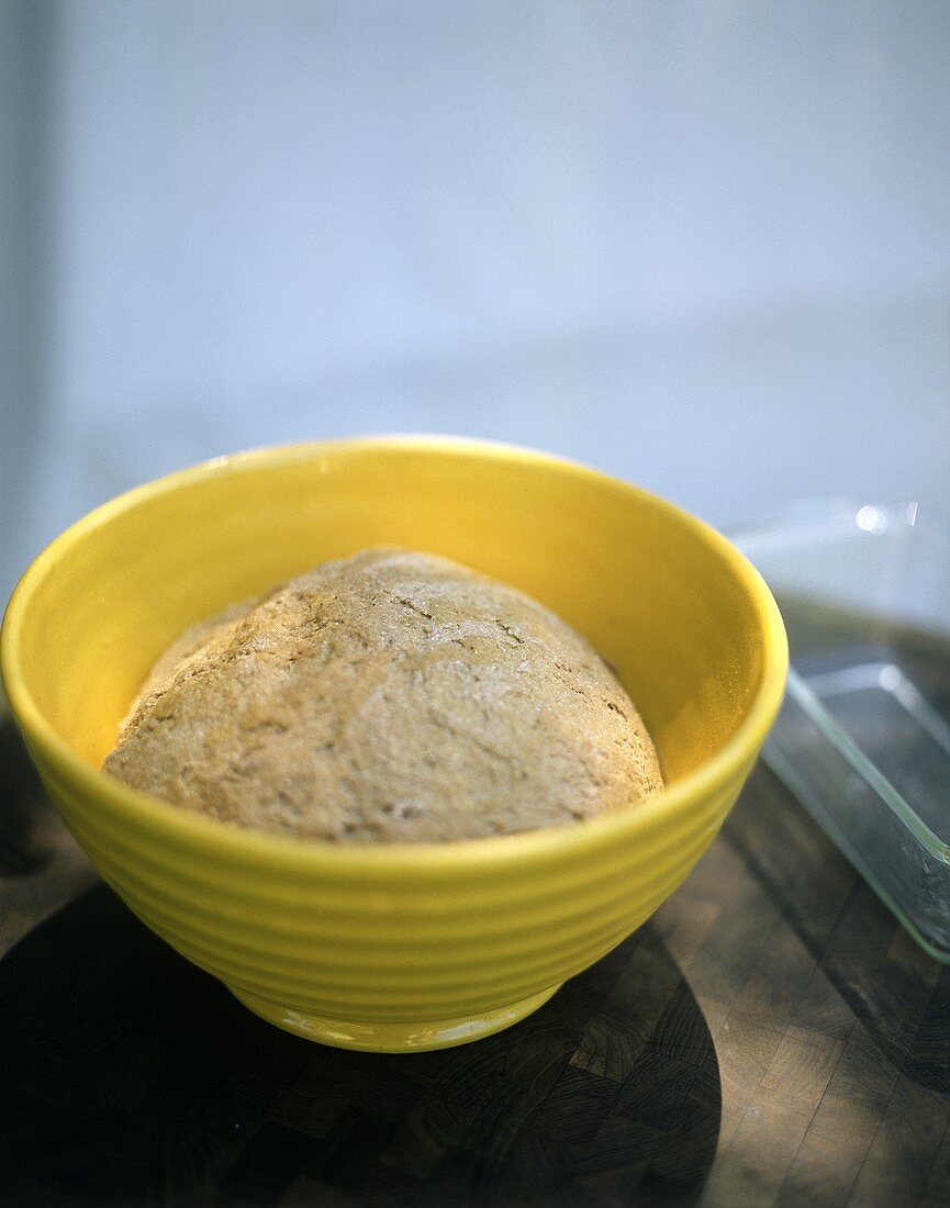 Bread dough in yellow bowl