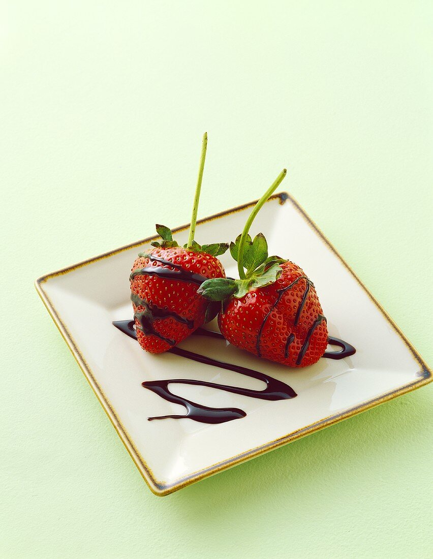 Two Strawberries with Chocolate Drizzles