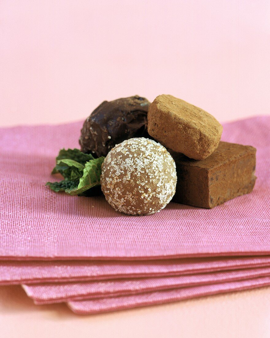 Four Chocolate Candies on Pink Linen