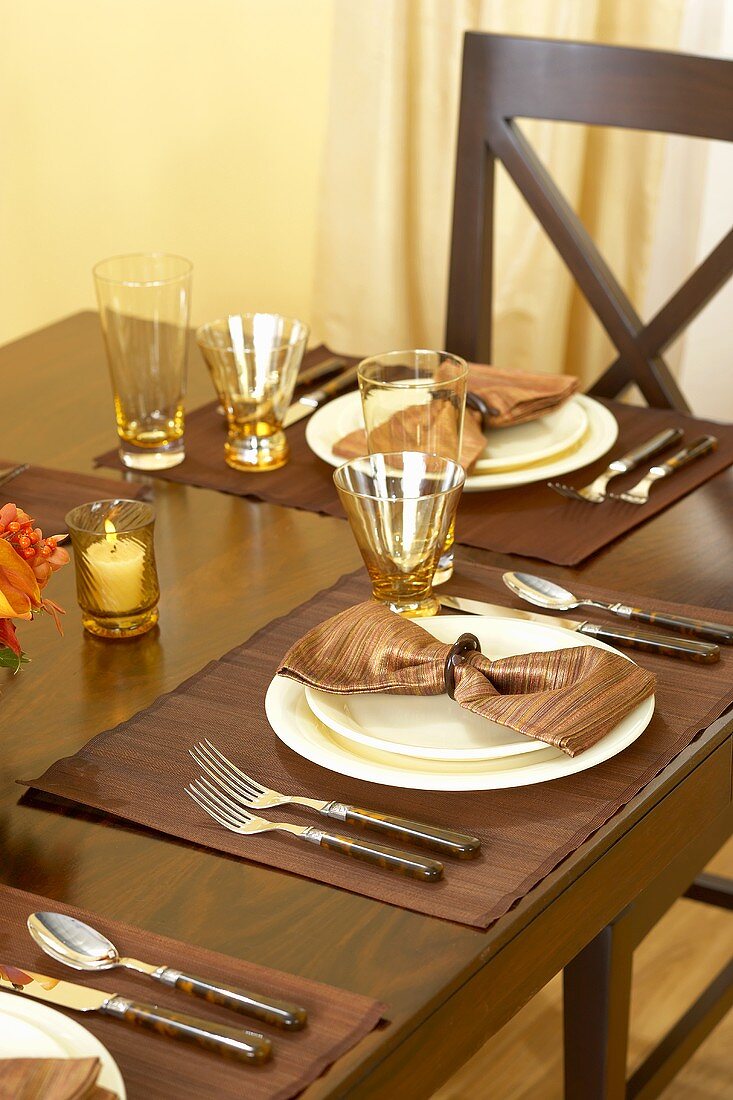 Gedecke mit braunen Servietten am herbstlich gedeckten Tisch