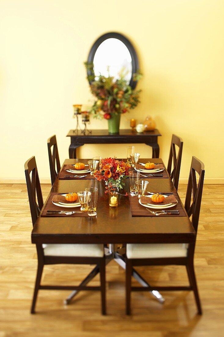 Herbstlich gedeckter Tisch mit Zierkürbissen im Wohnzimmer