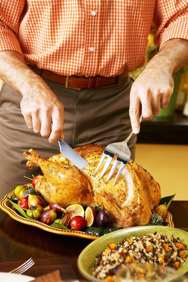 Mann tranchiert gebratenen Turkey zu Thanksgiving