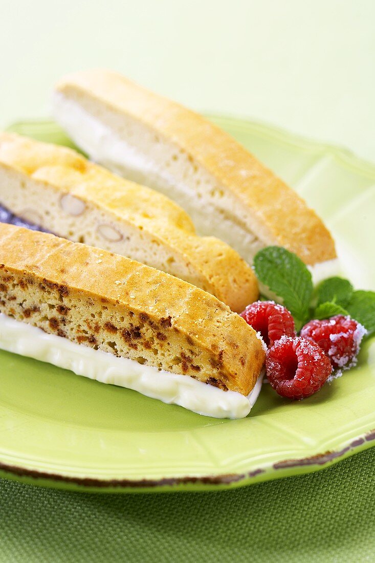 Biscotti mit Schokoladenglasur und Himbeeren auf Teller