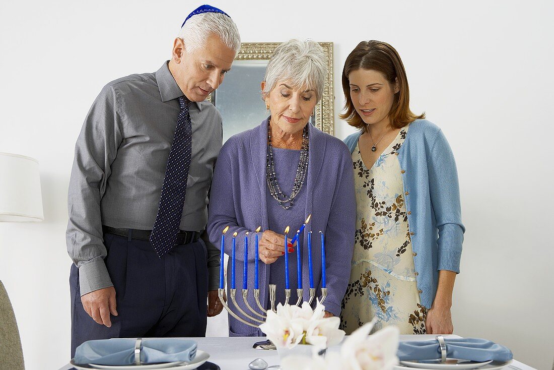 Frau zündet Kerzen an zu Hannukah