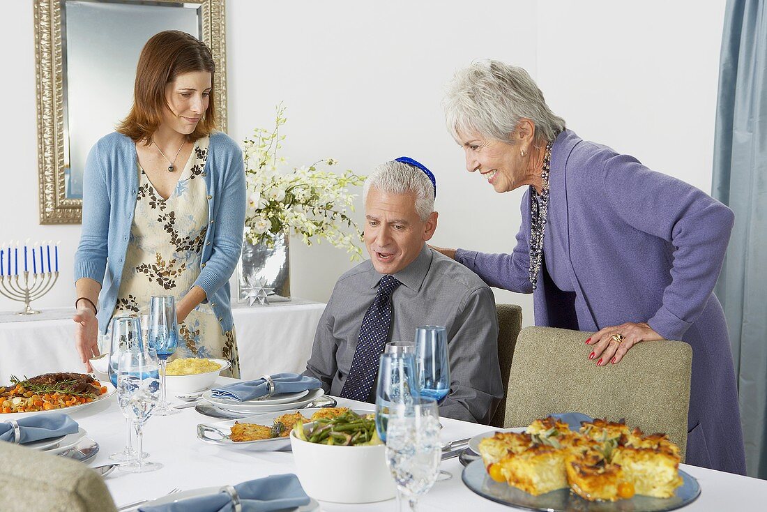 Familie am gedeckten Tisch zu Hannukah