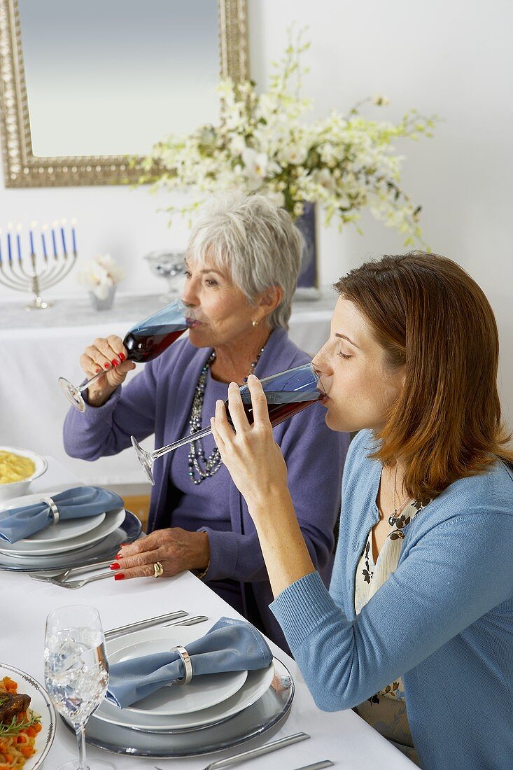 Two Women Drinking Red Wine at Hanukkah Diner Table