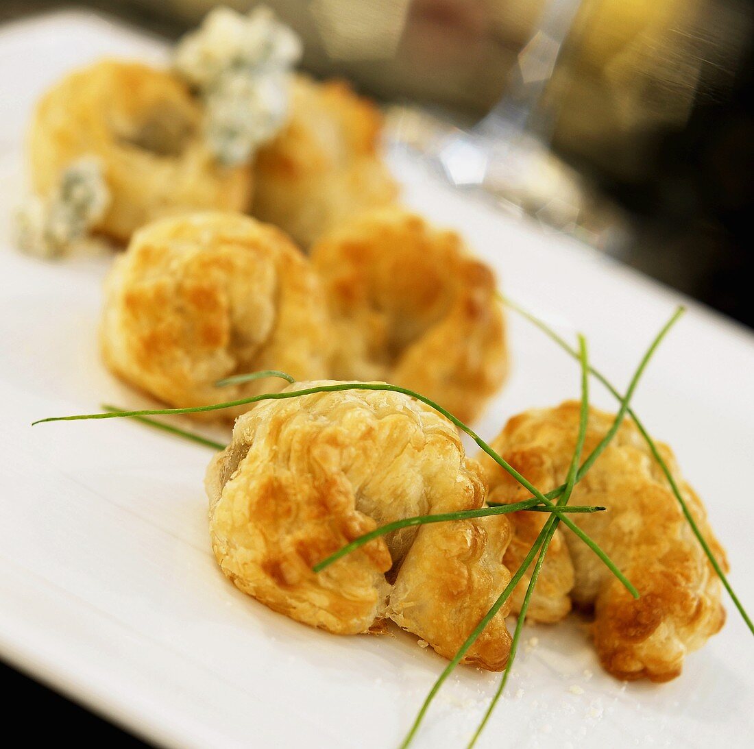 Appetizer Platter of Olive Stuffed Puff Pastry with Chive Garnish