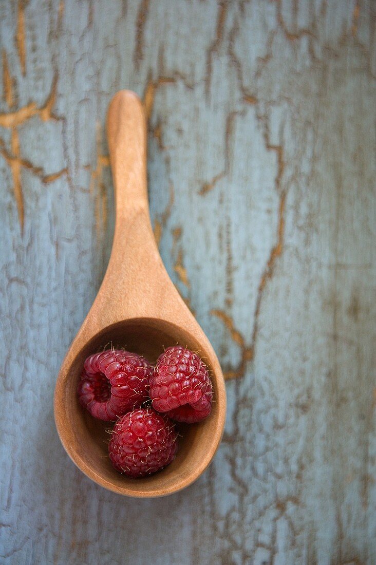 Drei Himbeeren auf Holzlöffel (Draufsicht)