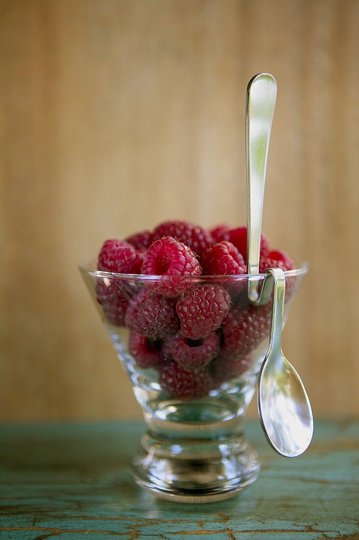 Himbeeren in Glasschale mit Löffel