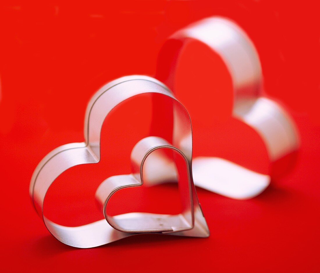 Three Assorted Sized Heart Shaped Cookie Cutters, Red Background