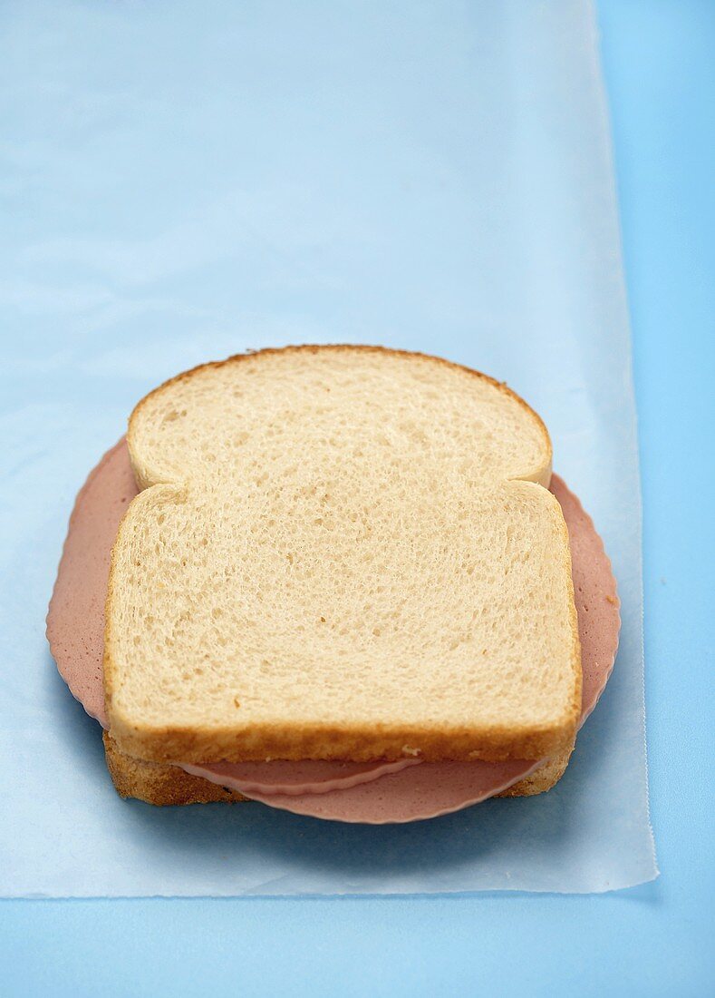 Sandwich mit Wurst auf Butterbrotpapier