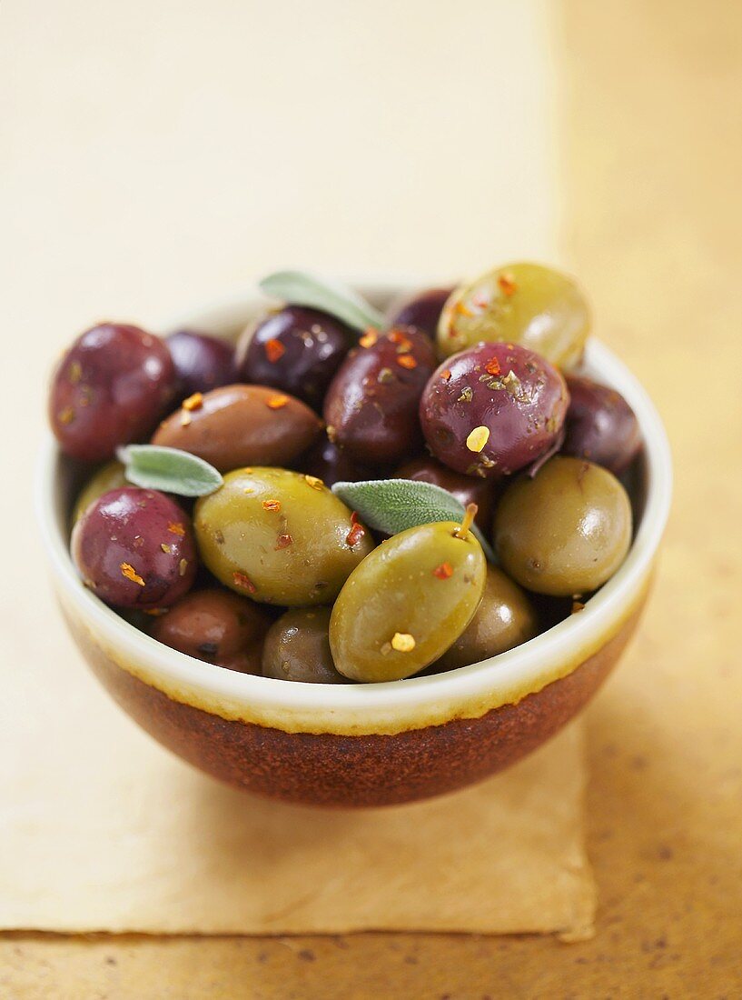 Marinierte Oliven mit Salbei in brauner Schale